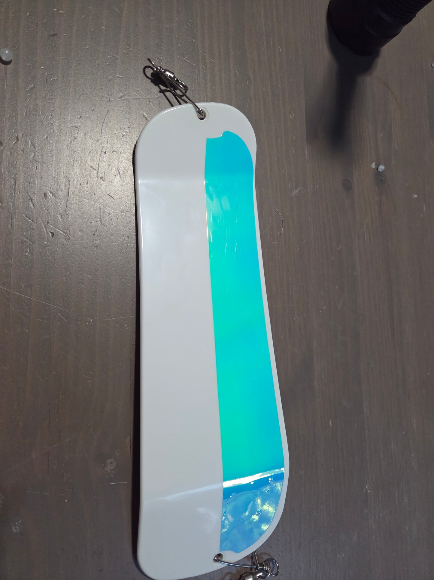 White lure with glow strip on a dark surface